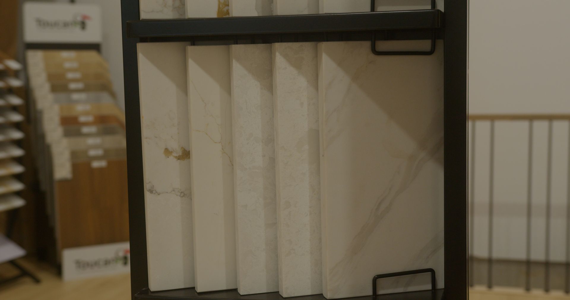 Un étalage de carreaux dans un magasin avec un escalier en arrière-plan.