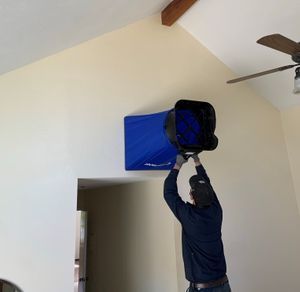 Technician using a flow hood to measure airflow for air balance