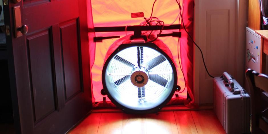 Technician performing a blower door test for home air leakage in Surprise, AZ