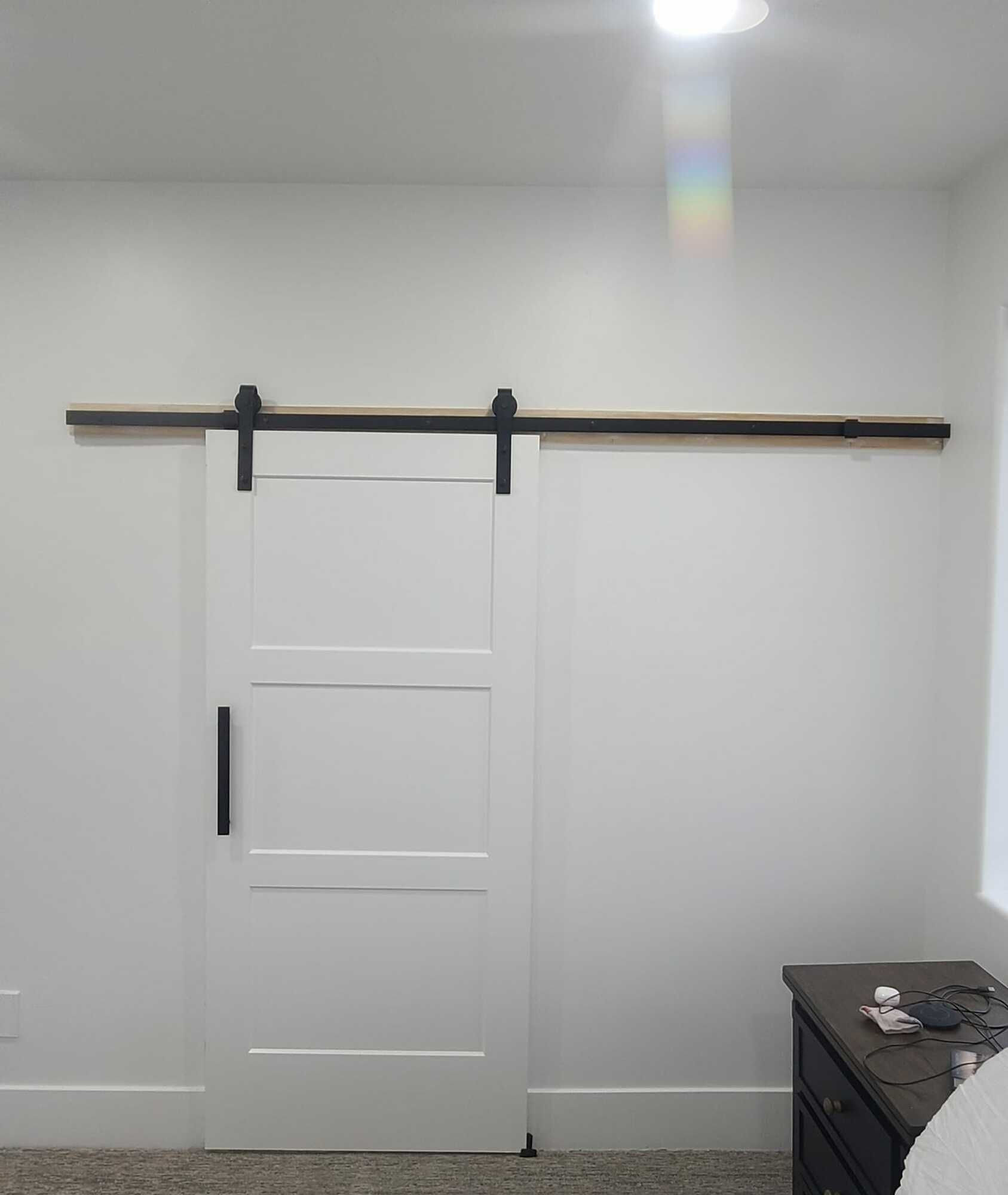 A bedroom with a sliding barn door and a nightstand.