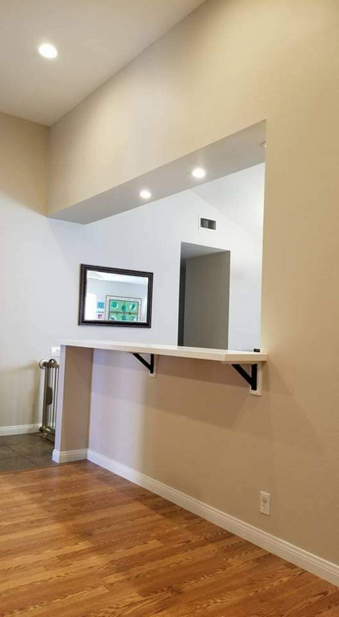 A kitchen with a counter and a mirror on the wall.