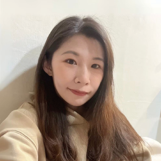 一名女子正在白牆前自拍。