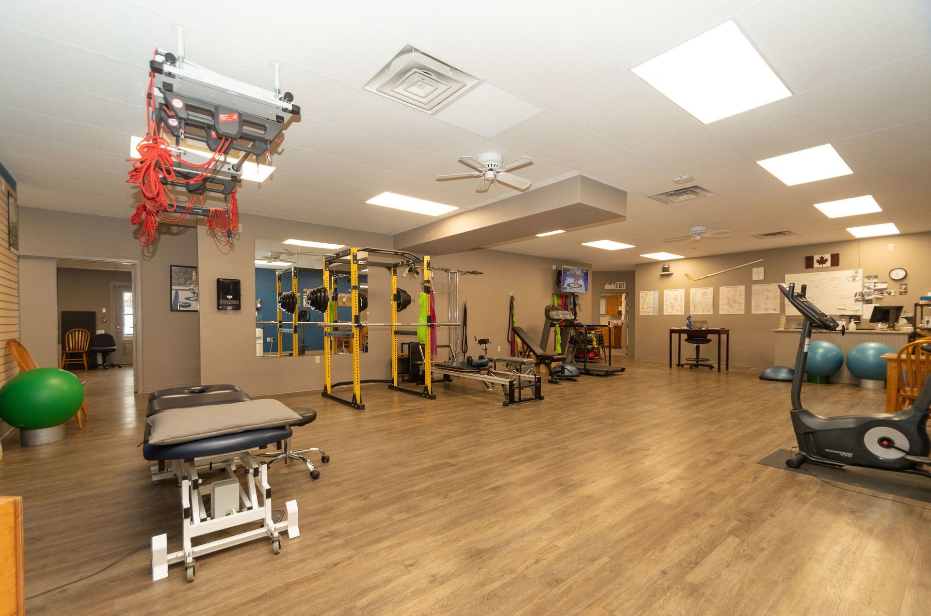A large gym filled with lots of exercise equipment and a treadmill.