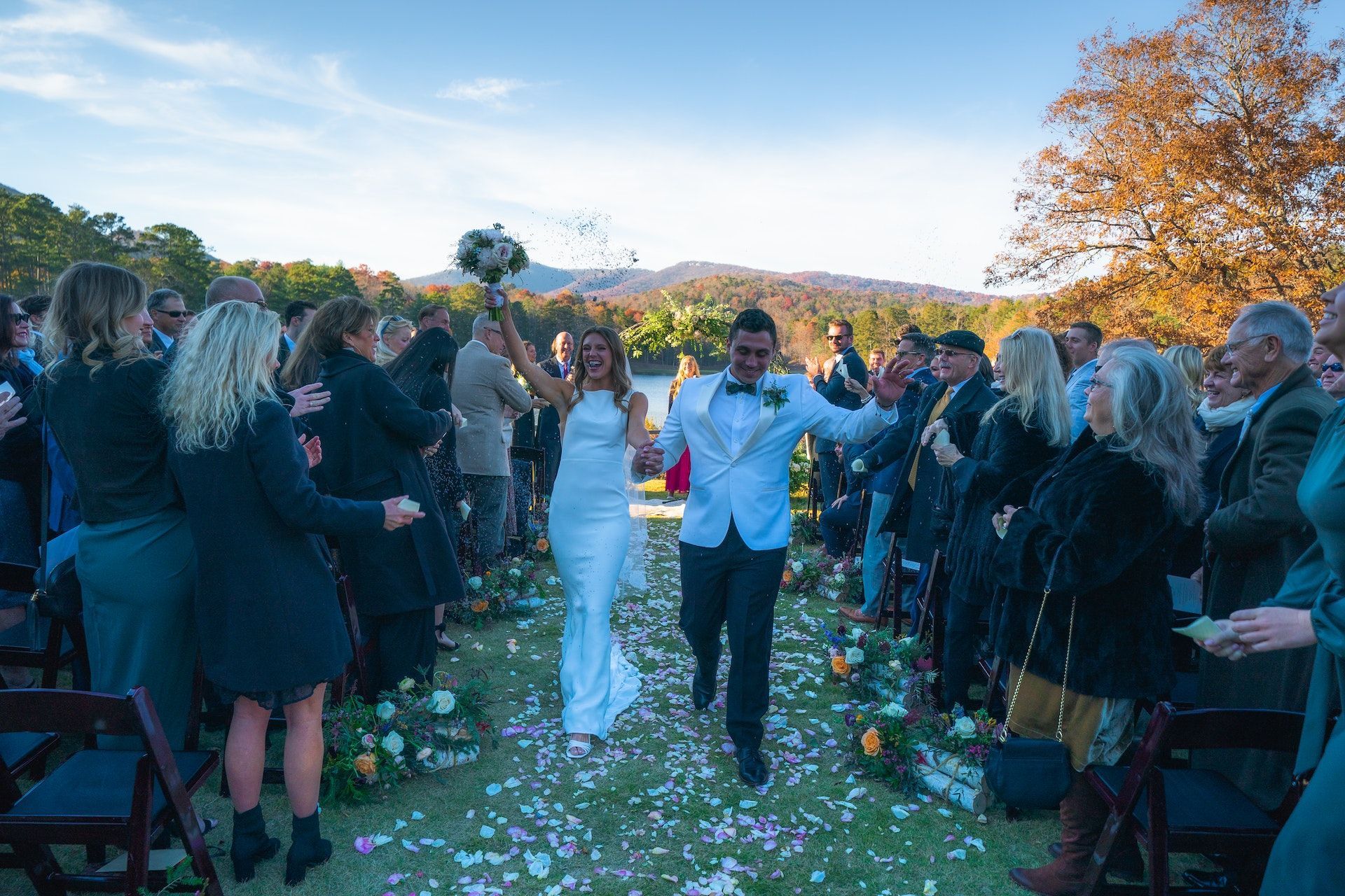 People Standing on Green Grass Field Watching the Married Couple