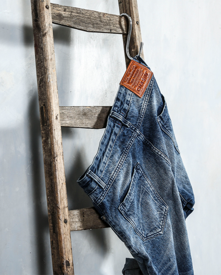 Spijkerbroek die aan een houten ladder hangt