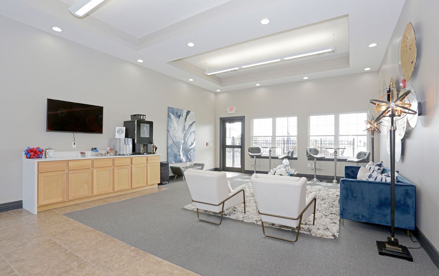 a living room with a blue couch and white chairs
