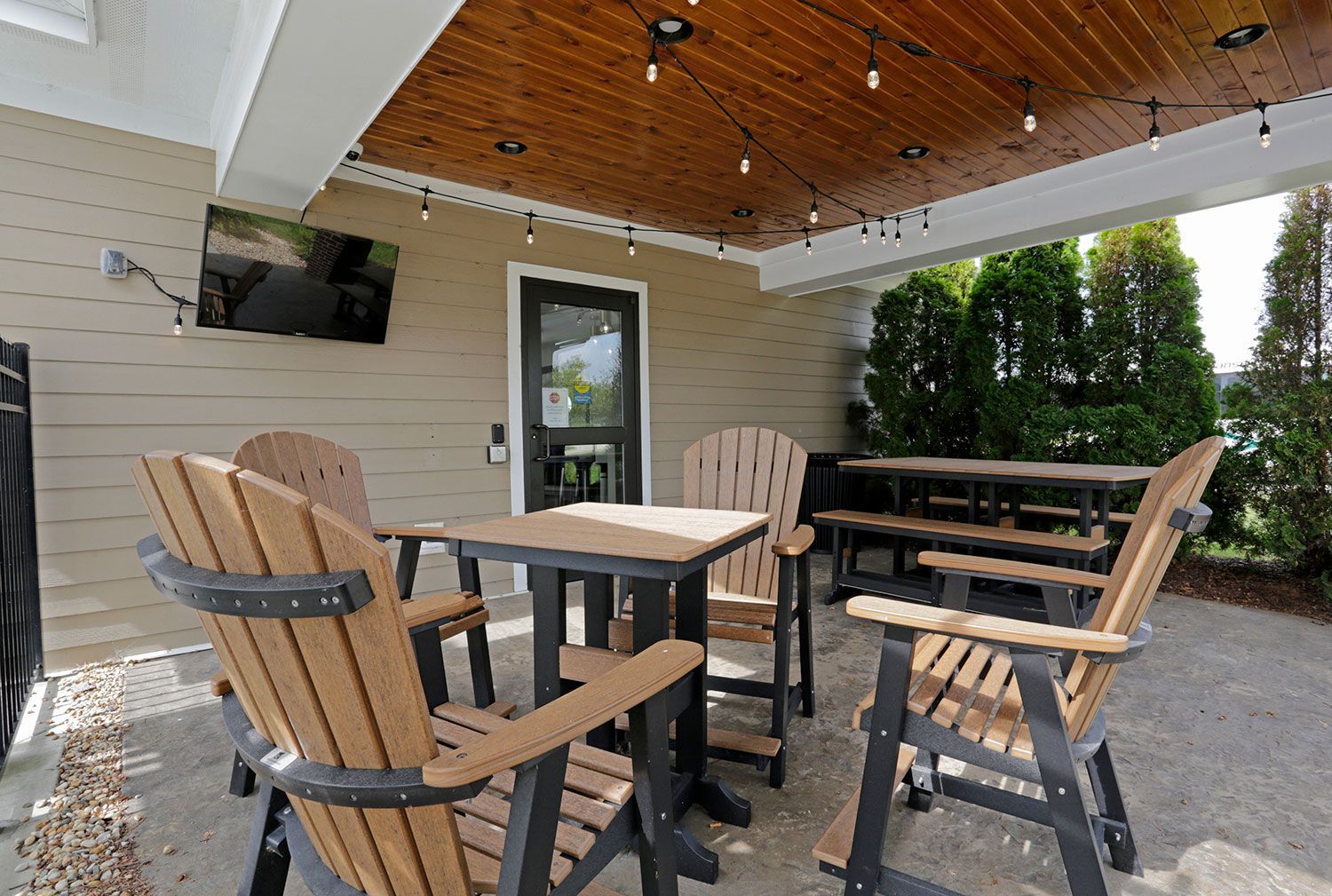 a patio with a table and chairs under a wooden ceiling