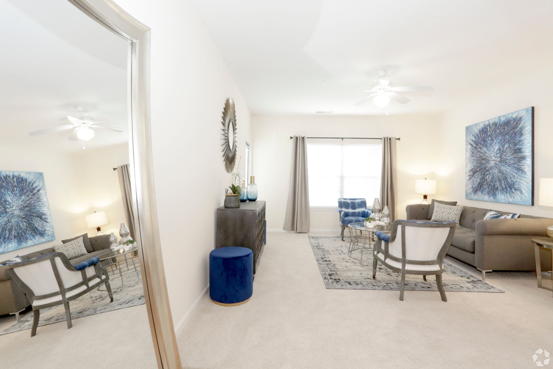 a living room with a couch and chairs and a mirror