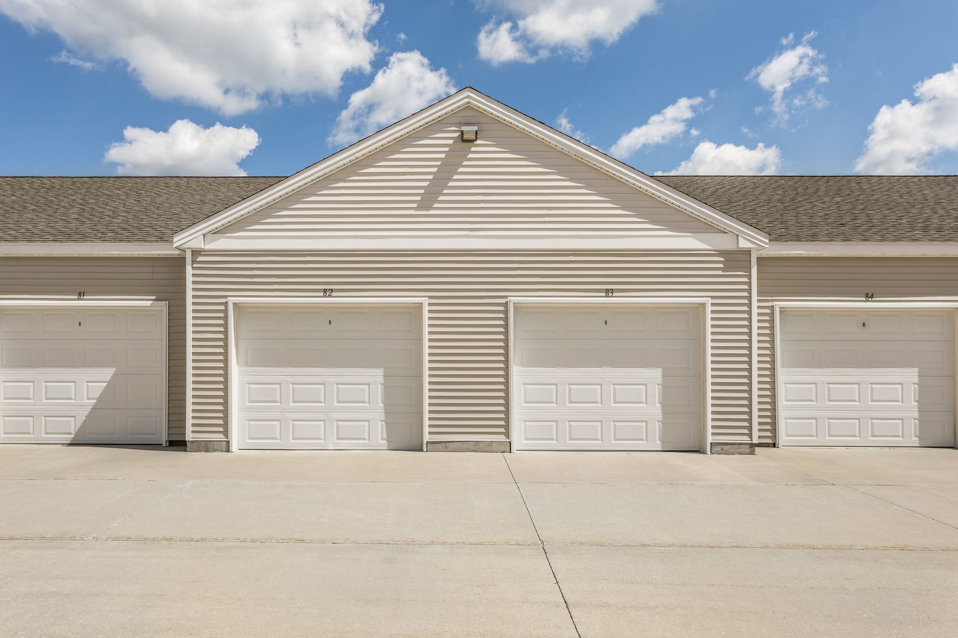 a row of white garage doors on a building
