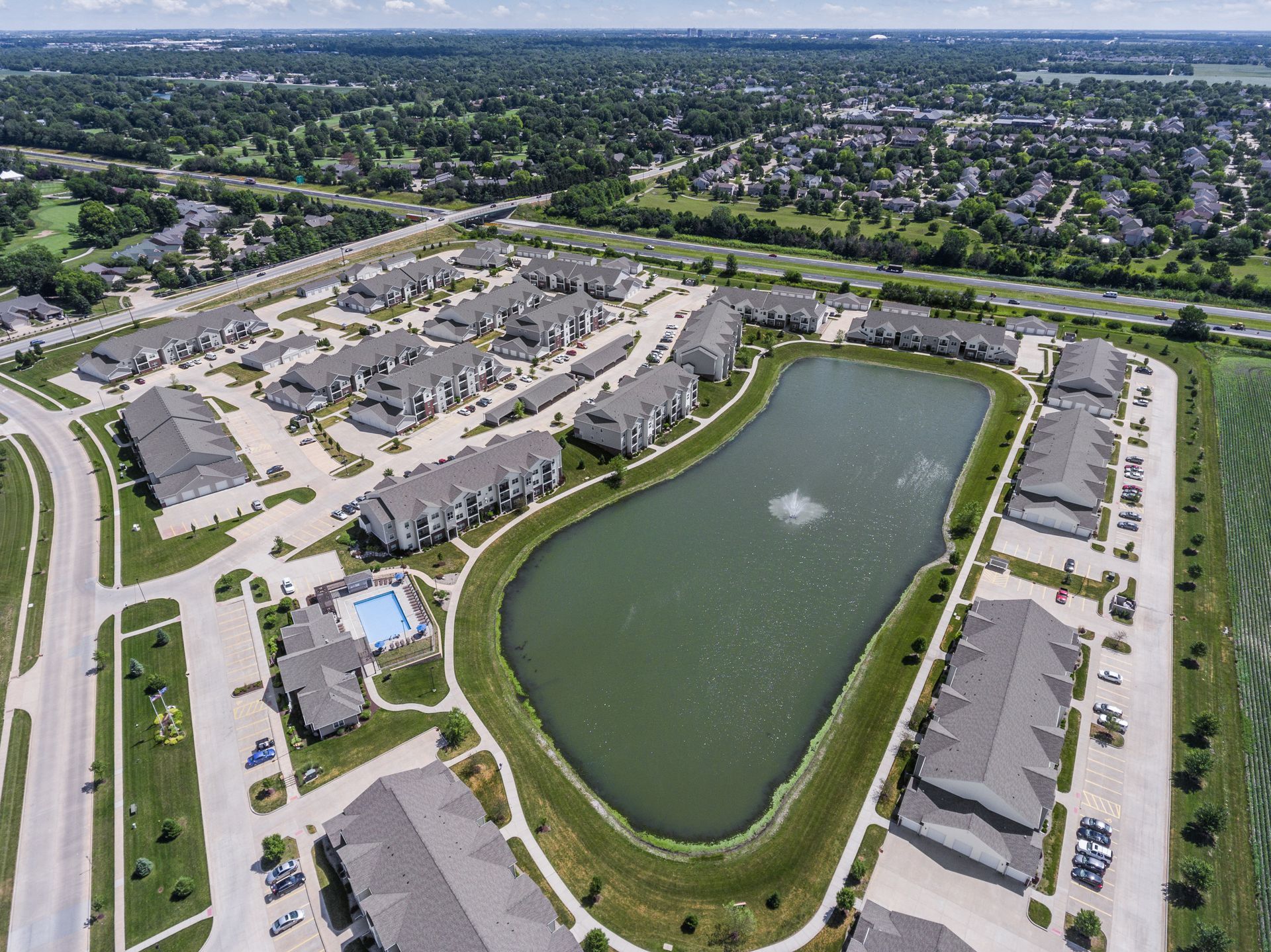 an aerial view of a residential area with a lake in the middle