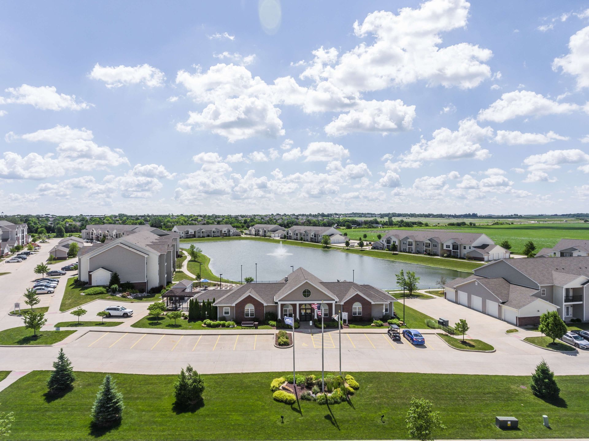 an aerial view of an apartment complex with a lake in the middle