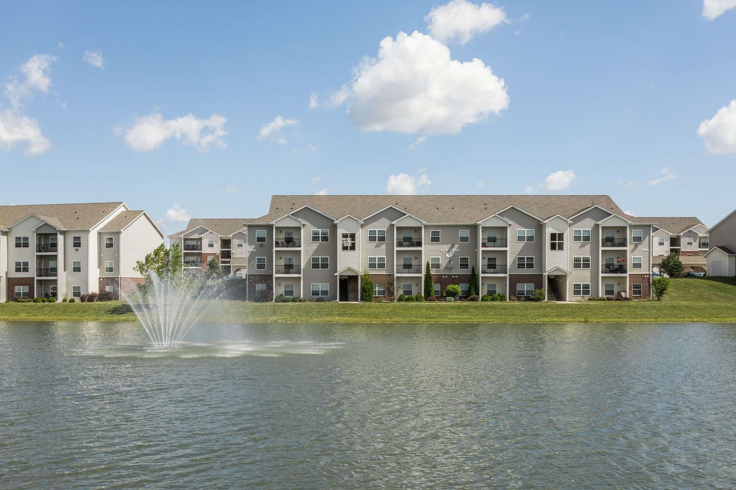 a large apartment building with a fountain in front of it
