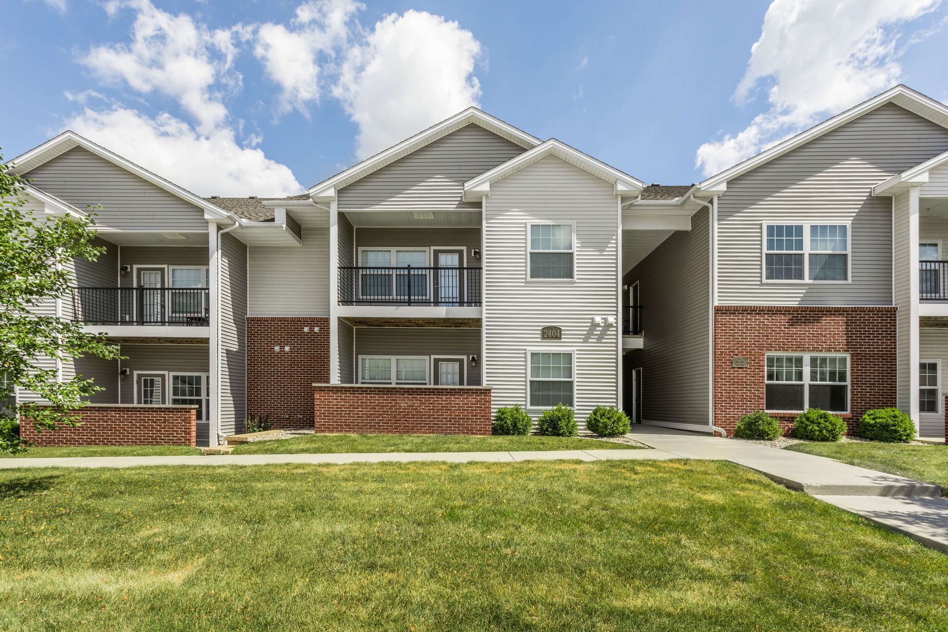 a row of apartment buildings with a large lawn in front of them