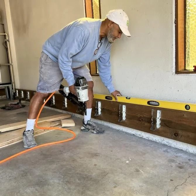 A man is measuring a wall with a level