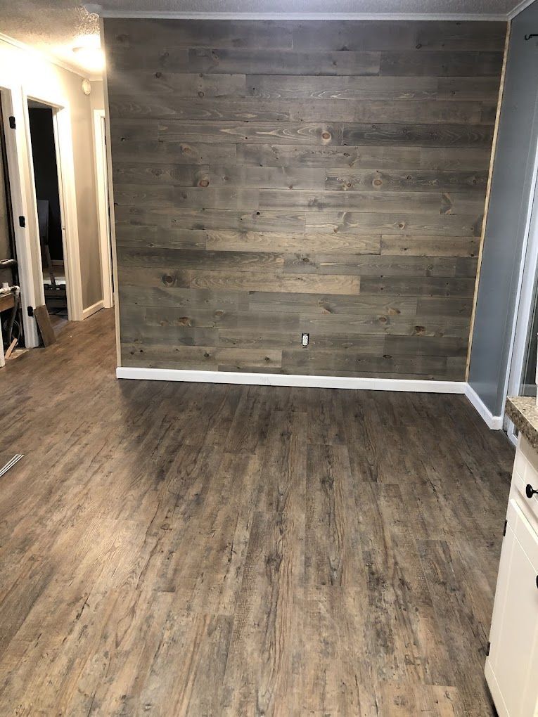 A large empty room with hardwood floors and a staircase.