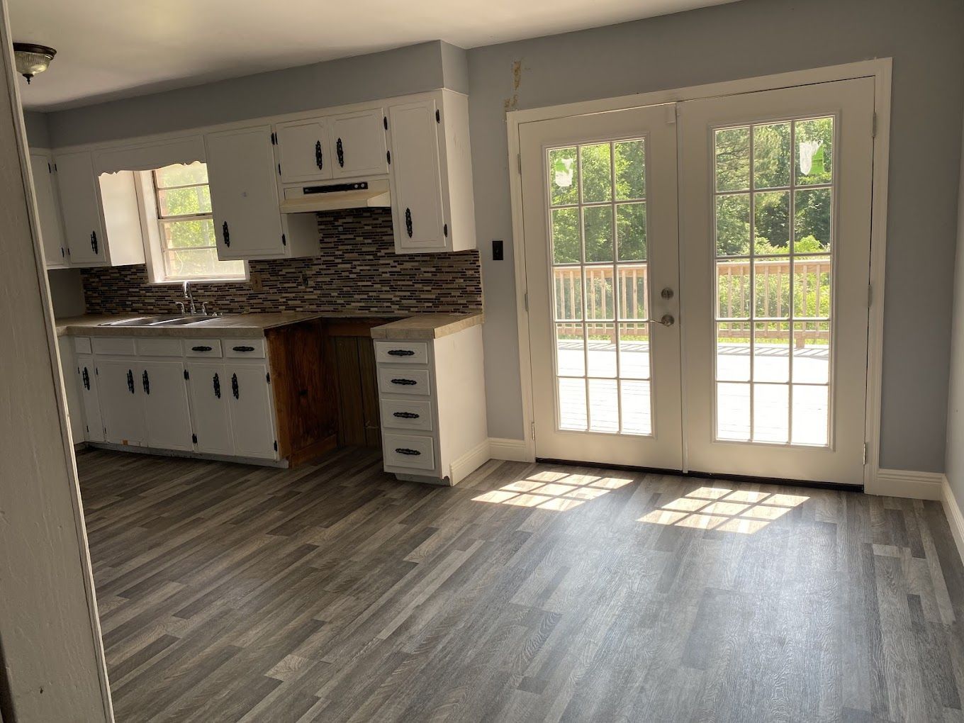 A person is painting a wooden wall with a brush.