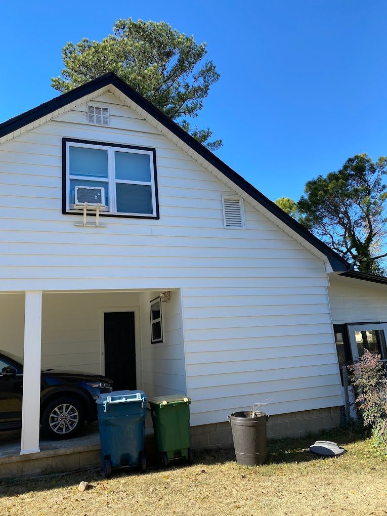 A white house with a car parked underneath it