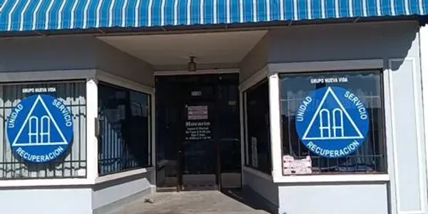 A building with a blue awning and a triangle on the windows.