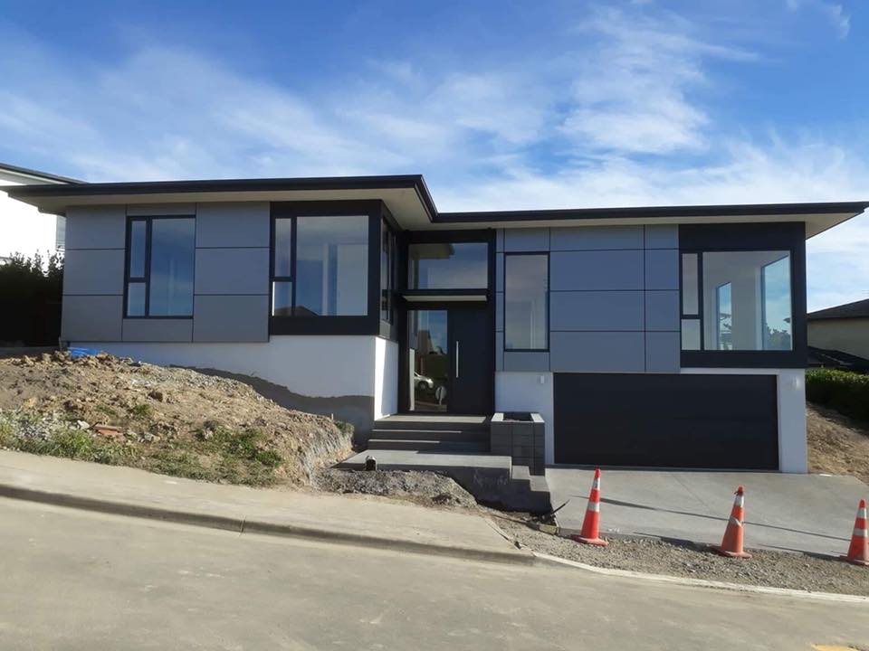 A house with a lot of windows is sitting on top of a hill