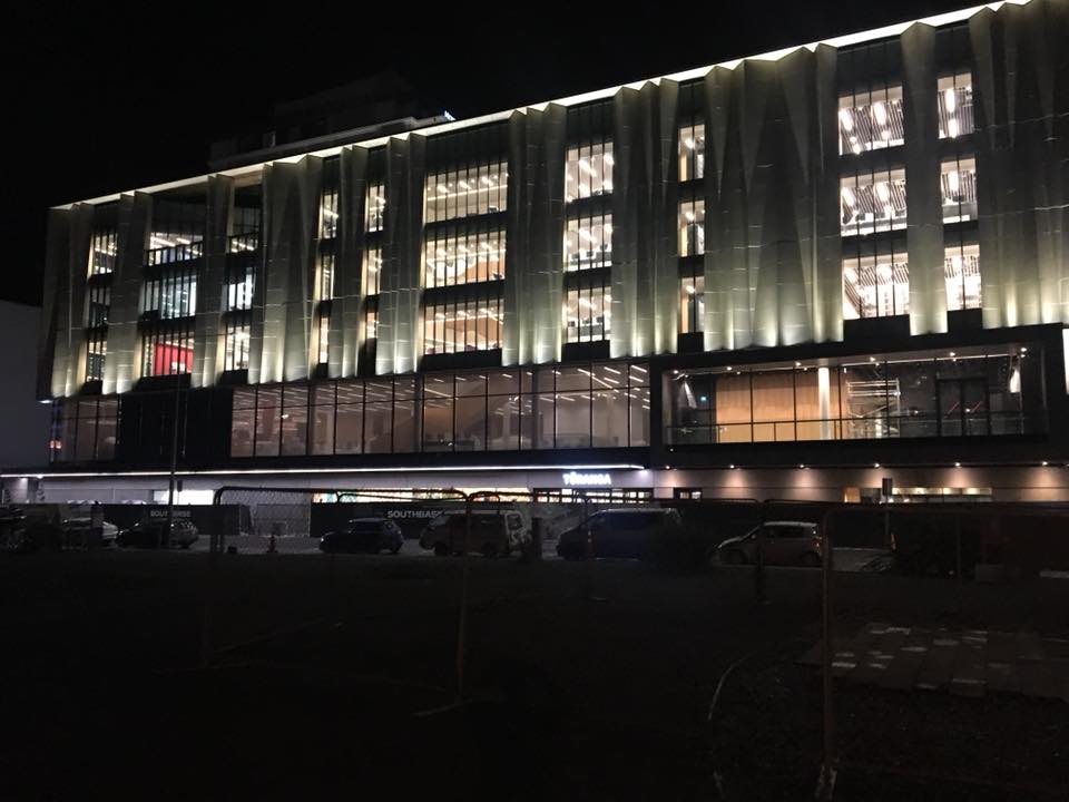 A large building with a lot of windows is lit up at night.