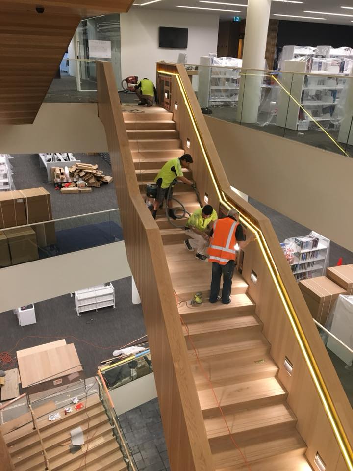 A group of people are working on a set of stairs in a building.