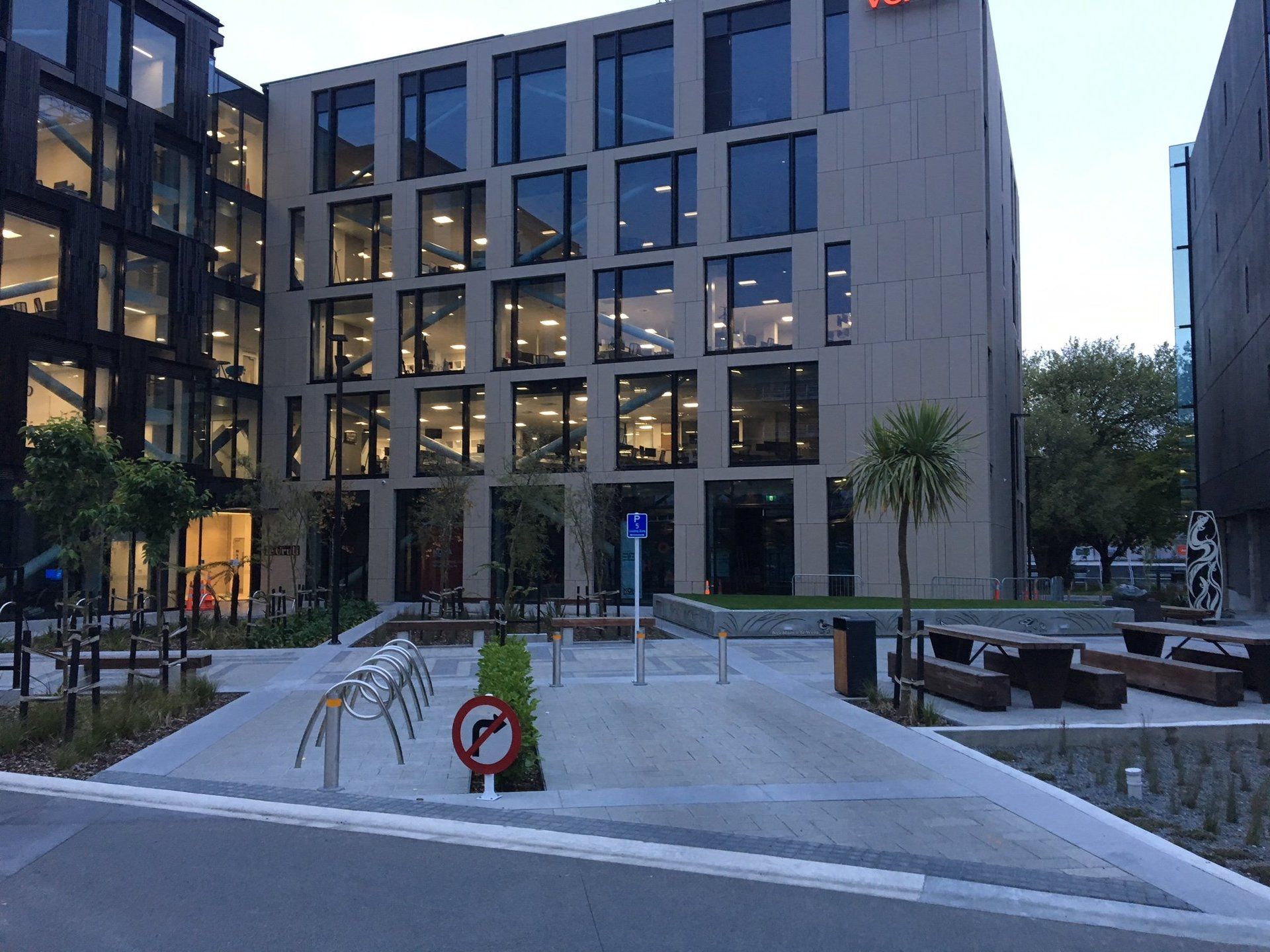A large building with a lot of windows and a parking lot in front of it.