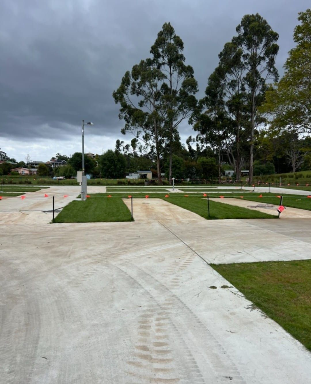 A parking lot with trees and a cloudy sky in the background