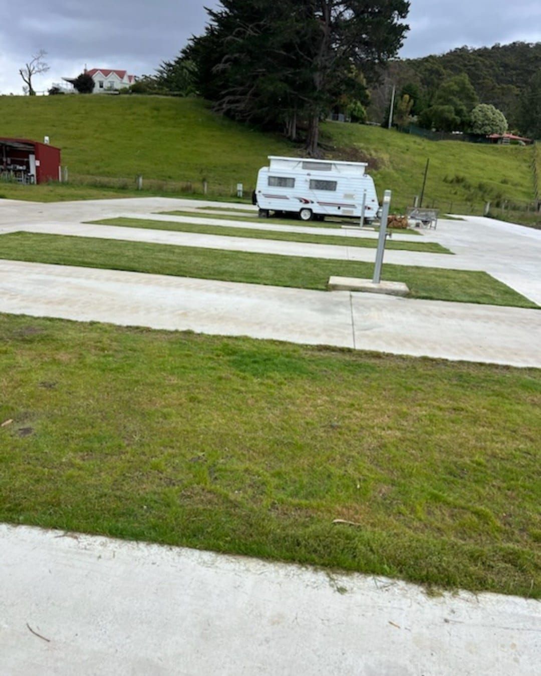 A white rv is parked in a grassy field