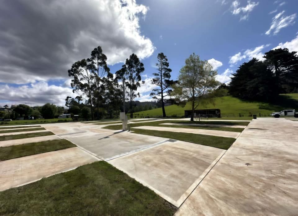 A parking lot with trees in the background on a cloudy day