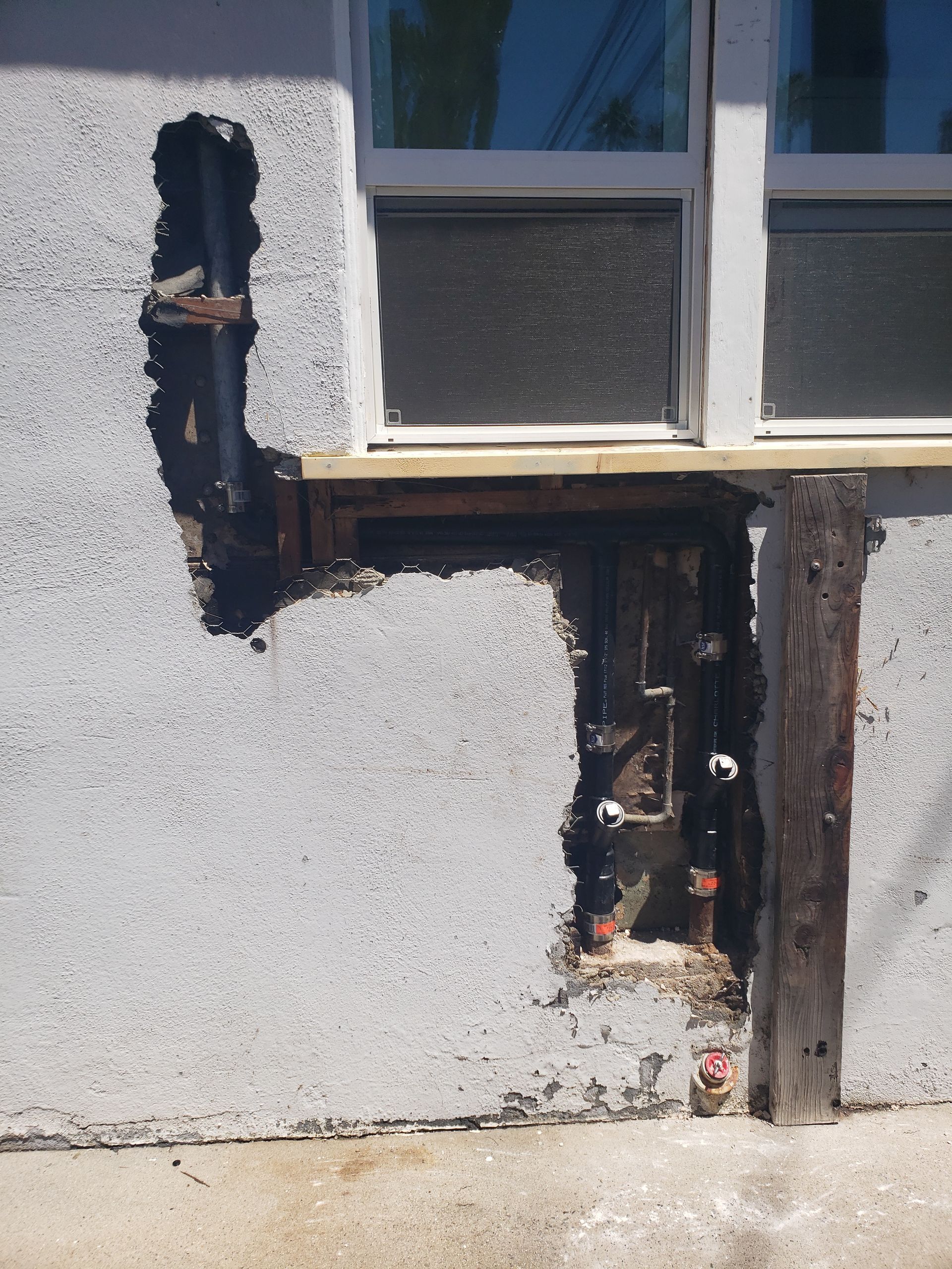 A concrete wall with a hole in it and a window