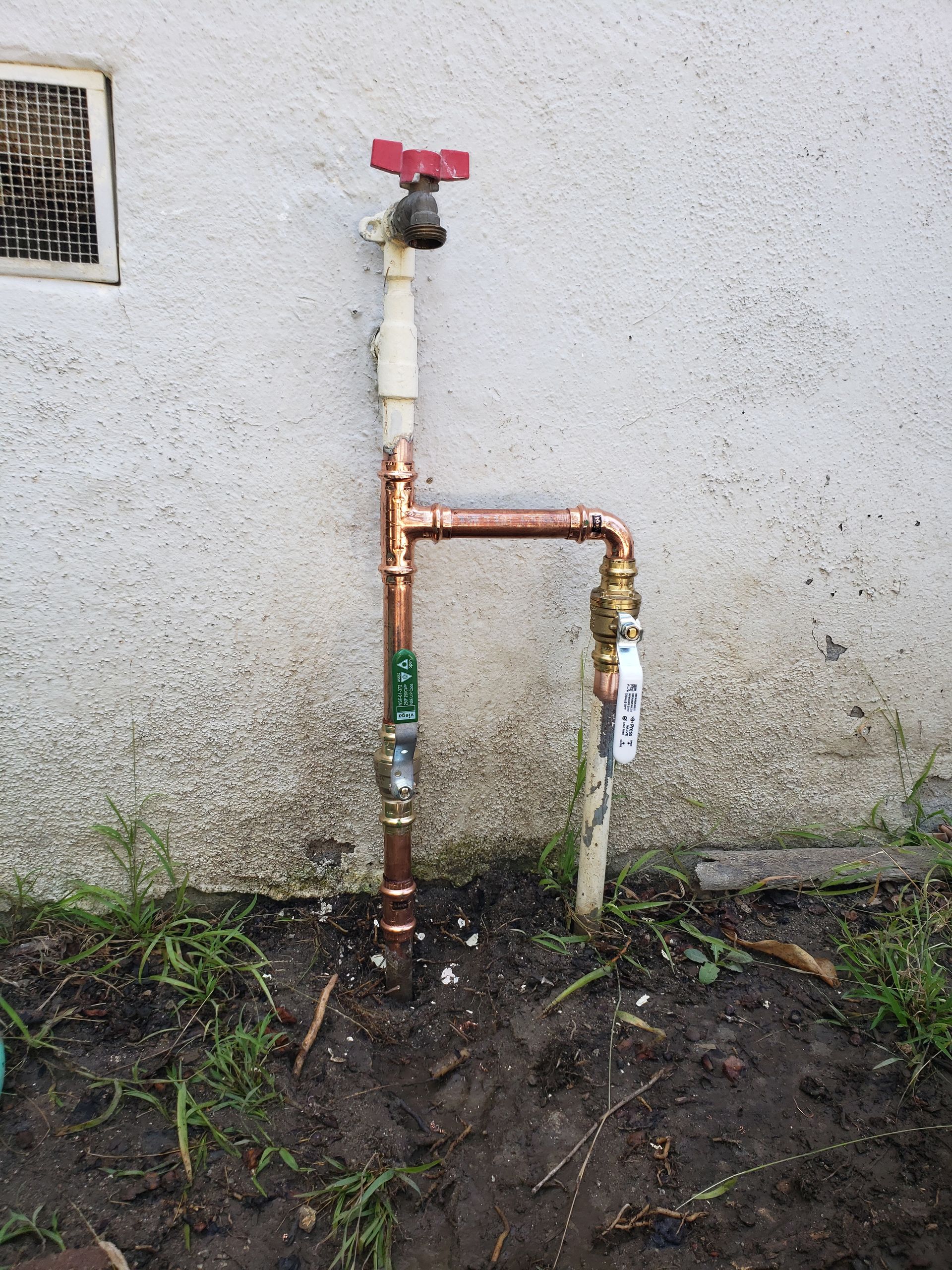 A copper pipe with a faucet attached to it