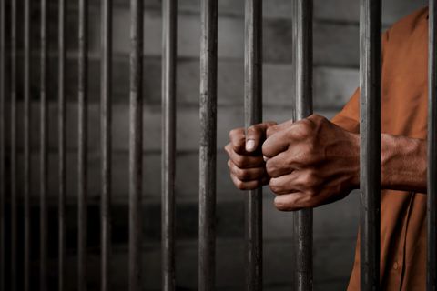 Man Holding on Prison Bars — Fort Pierce, FL — A Johnson Bail Bonds