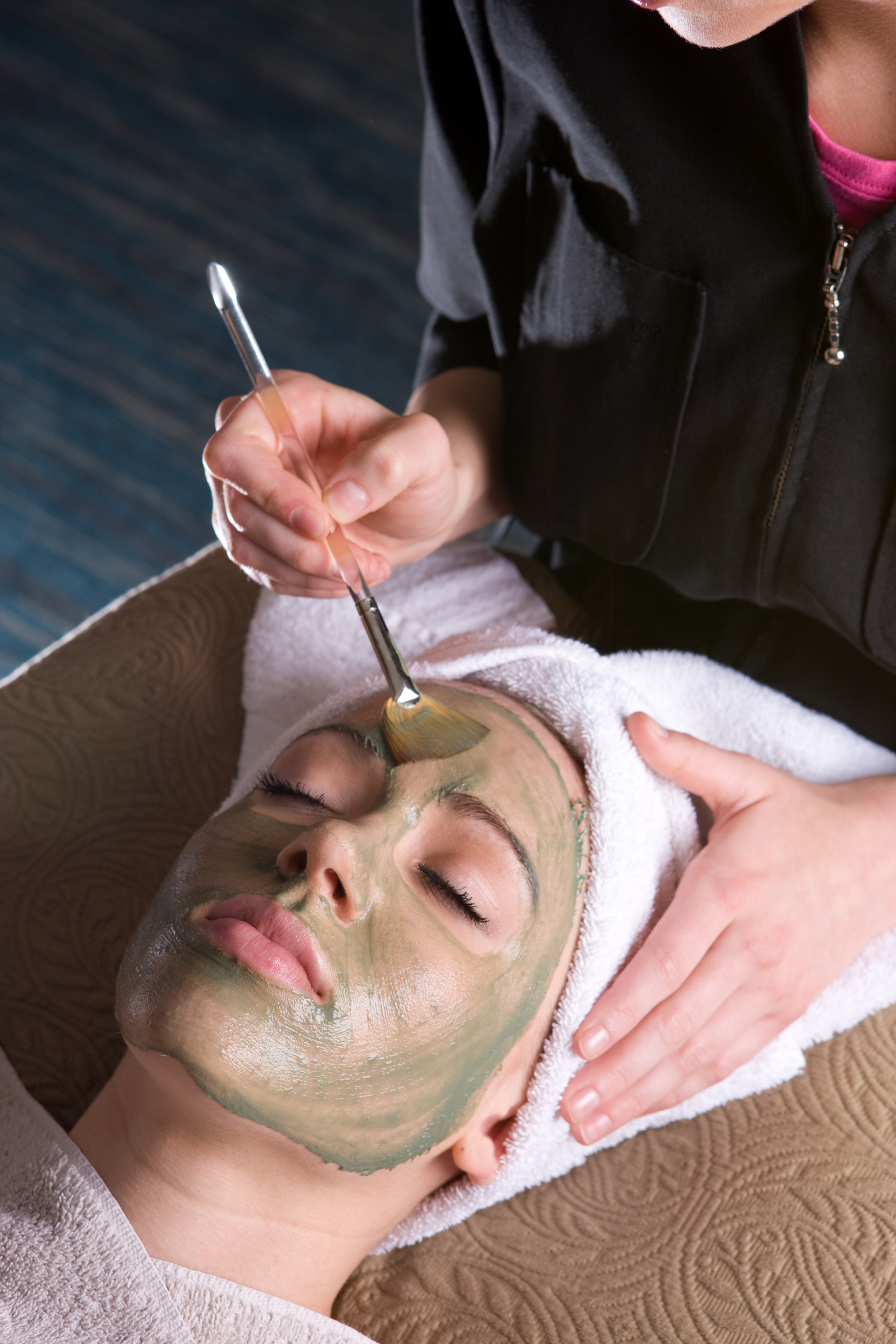 A woman is getting a facial treatment at a spa.