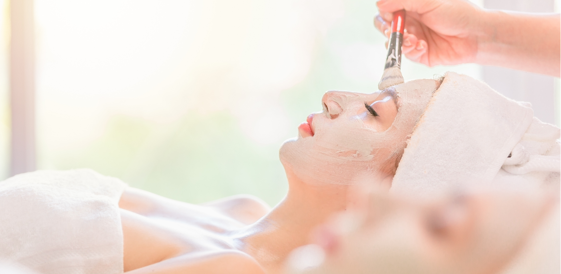 A woman is getting a facial treatment at a spa.