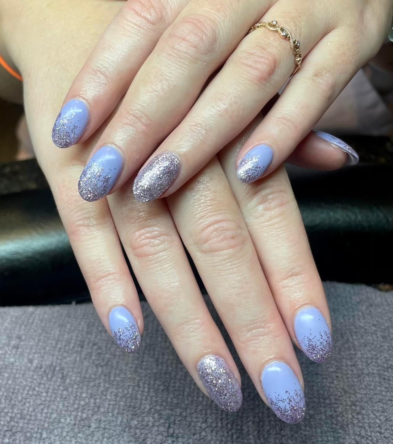 A close up of a woman 's nails with a ring on her finger