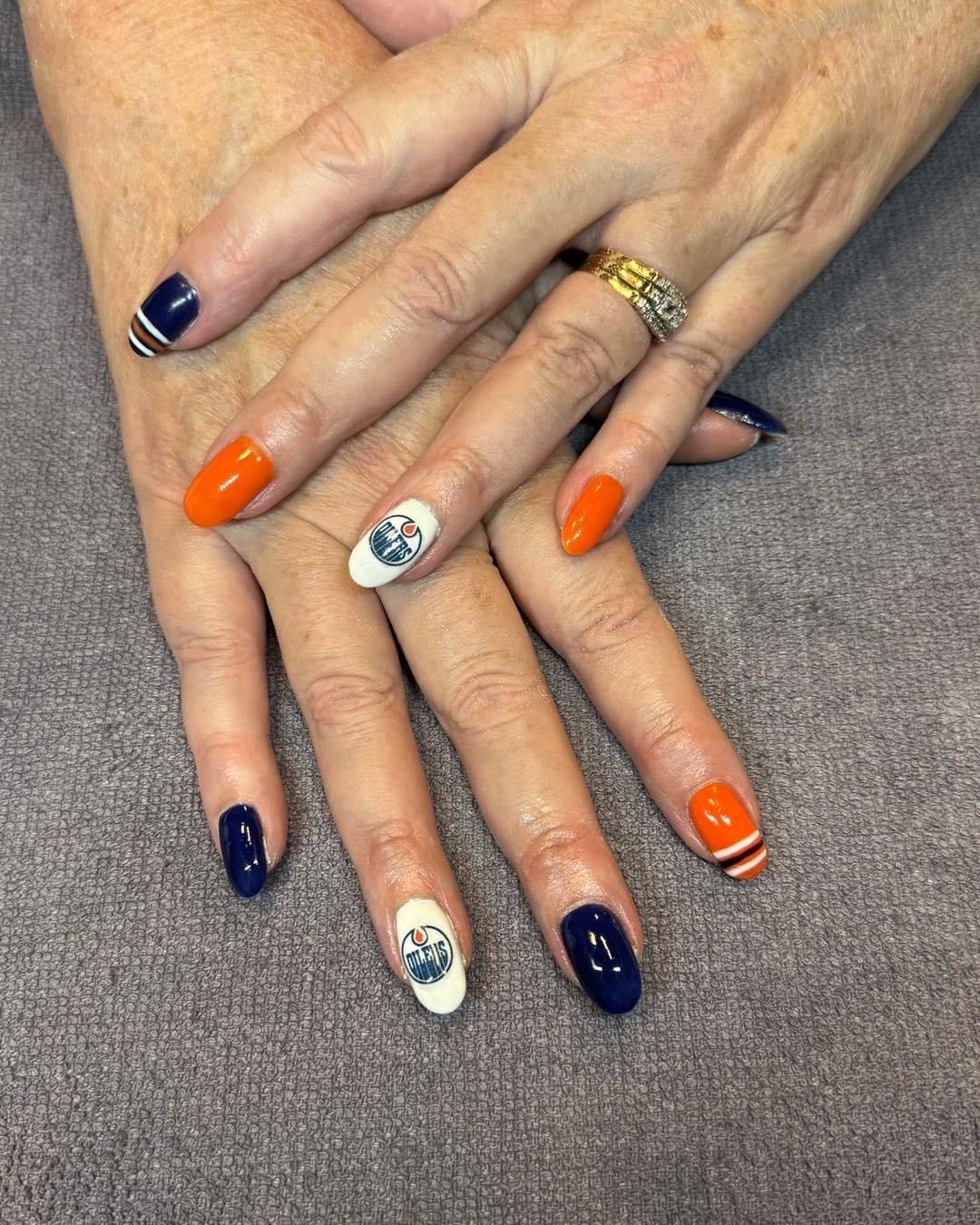 A close up of a woman 's nails with a ring on her finger.