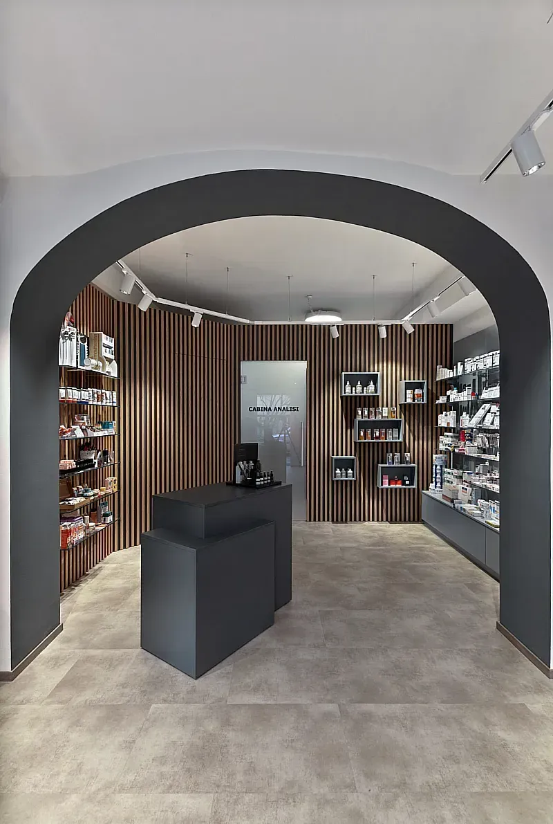 Arredamento Farmacia Ferrero Novara, banco cosmesi in laminato verde pietra, struttura di rivestimento parete tramite doghe in mdf in rovere naturale e spazi antracite; expo a parete con cassettoni e ripiani