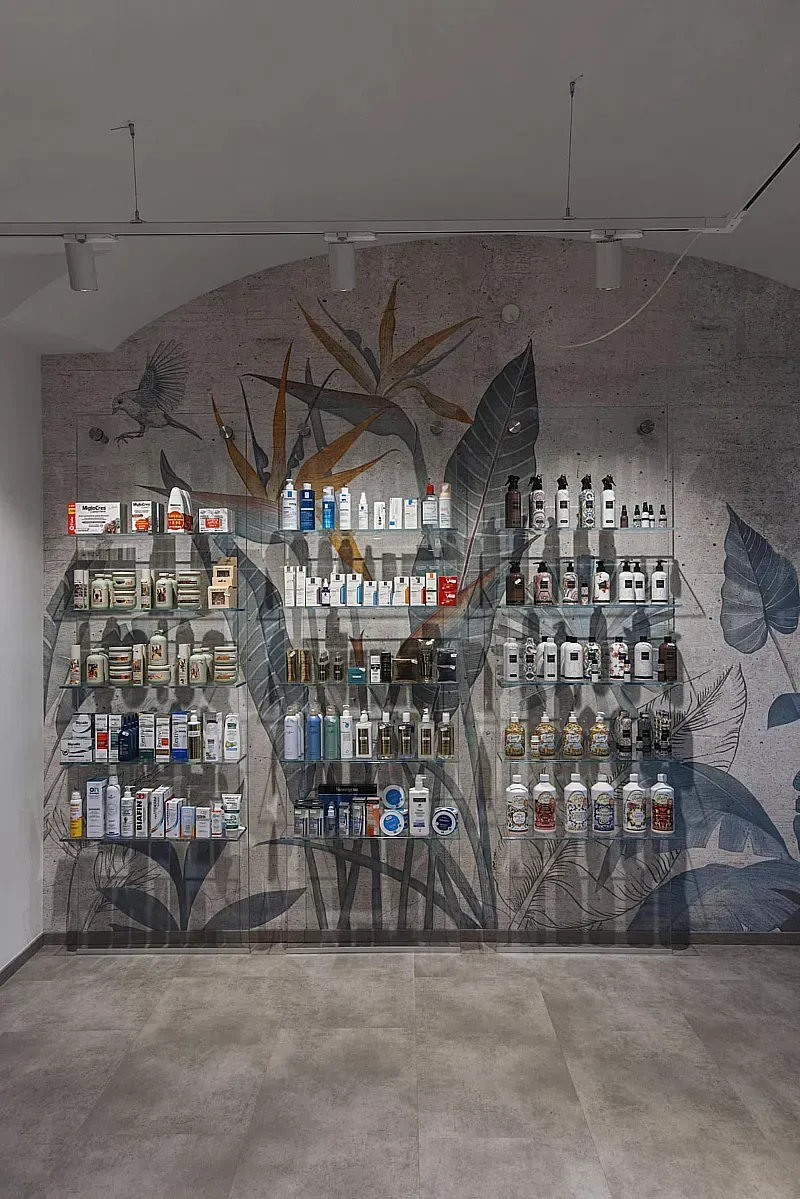 Arredamento Farmacia Ferrero Novara, parete rivestita in carta da parati, lastre in vetro temperato con ripiani fissati con lampada uv