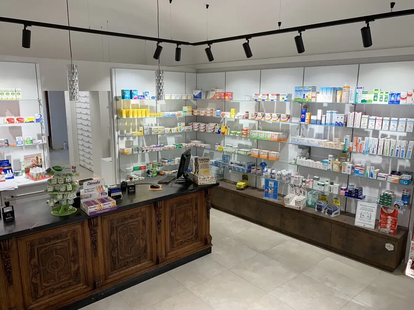 Arredamento Farmacia del Vernato Biella banco, retrobanco, binario e faretti illuminazione