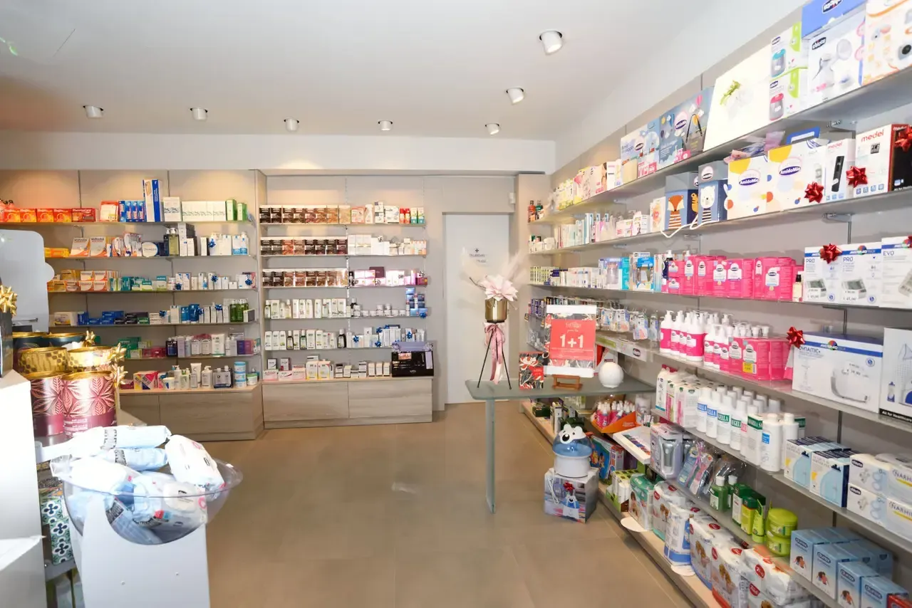 Arredamento Farmacia Ferretti Borgo D'Ale expo a parete e banco cosmesi in uscita da expo con piano e gamba in vetro acidato