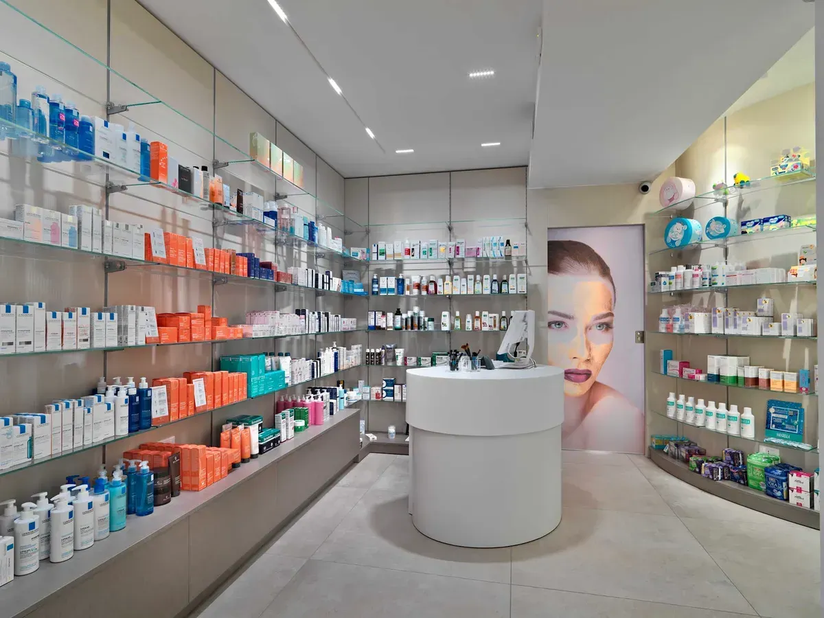 Arredamento Farmacia Passirani Lesa, banco cosmesi, expo a parete con ripiani e cassettone