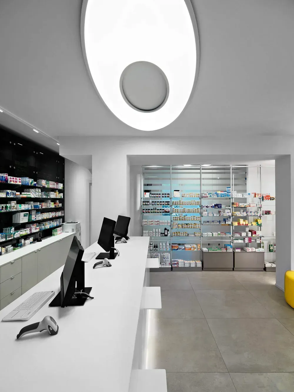 Arredamento Farmacia Passirani Lesa, banco e lampada Elcom, progetto della light designer Bianca Tresoldi