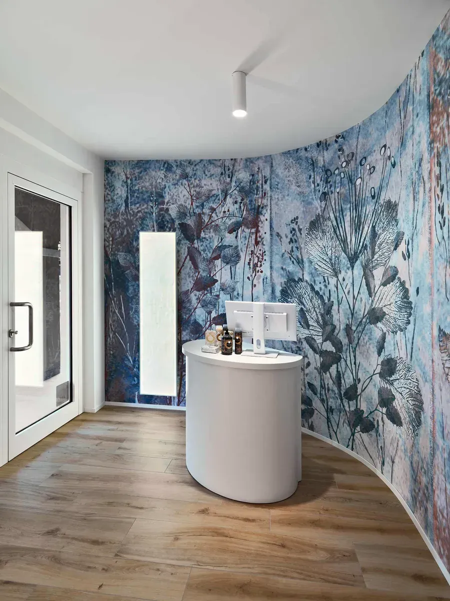 Arredamento Farmacia Passirani Lesa, banco cassa con stile simile al cosmesi e parete con carta da parati