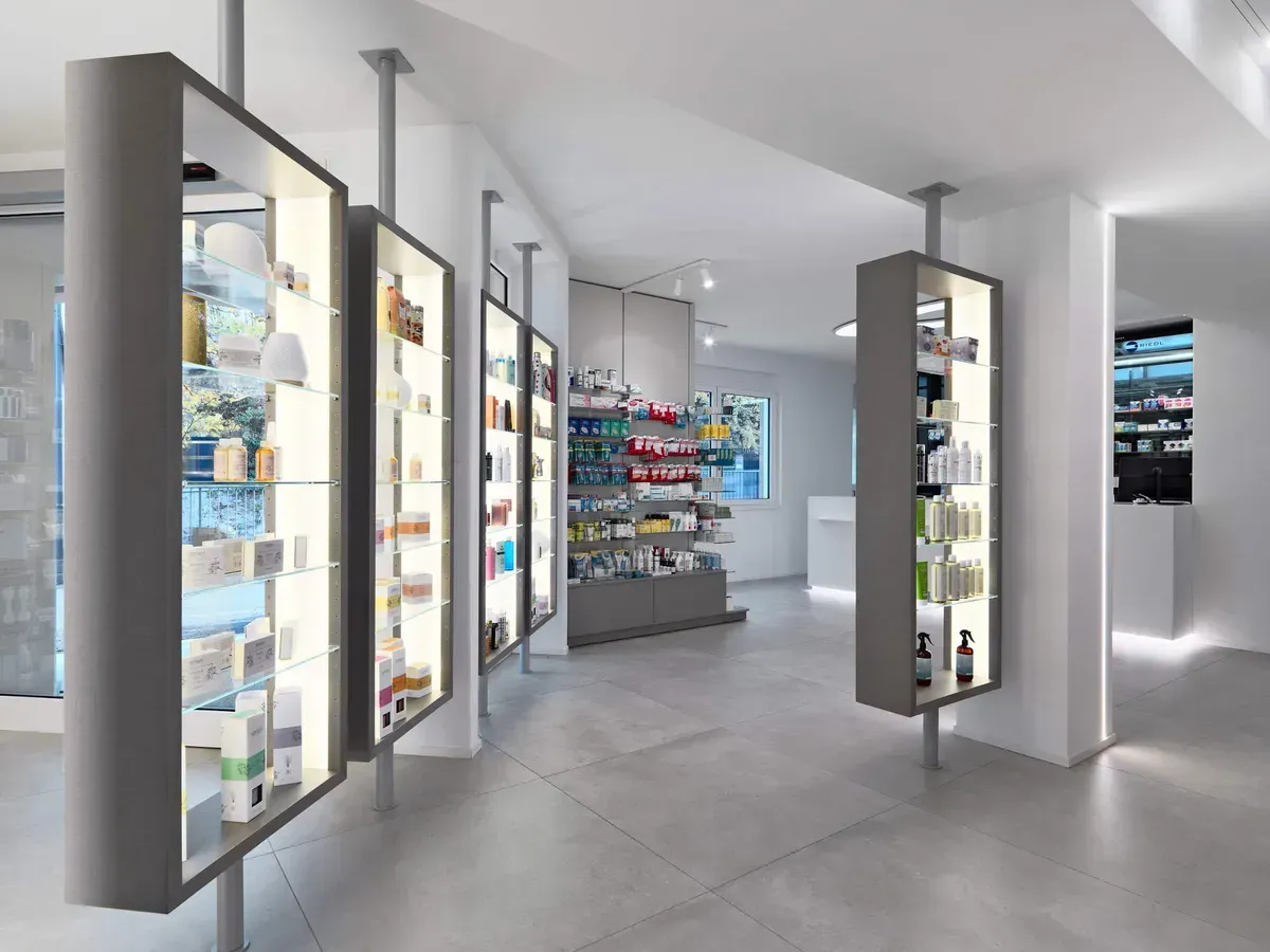 Arredamento Farmacia Passirani Lesa, expo illuminati con ripiani e attacco pavimento e soffitto