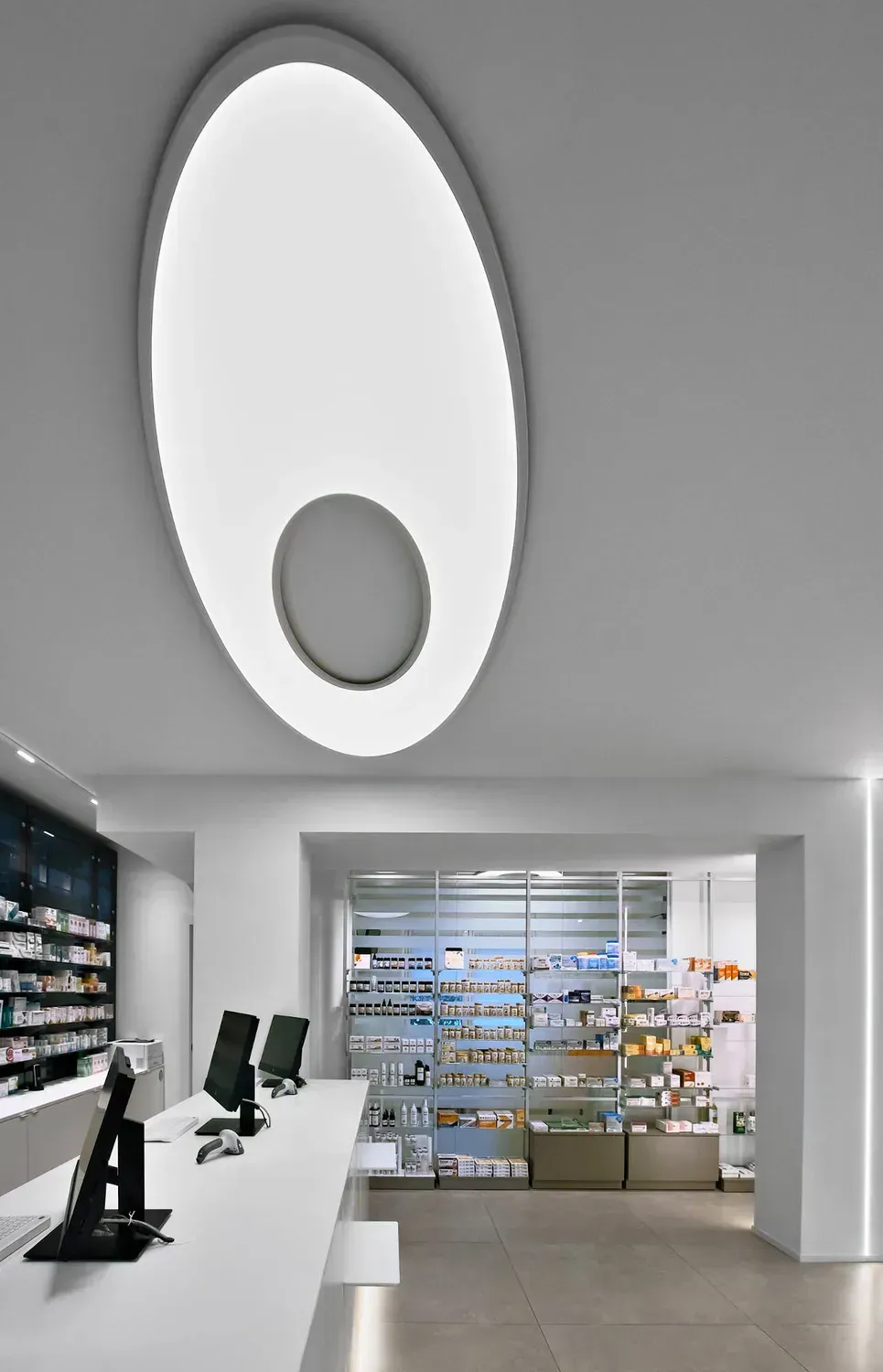 Arredamento Farmacia Passirani Lesa, banco cassa e lampada Elcom, progetto unico realizzato su misura
