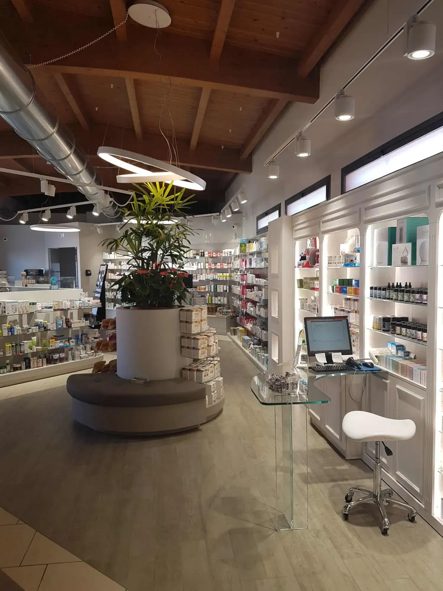 Arredamento Farmacia Sandigliano Biella, expo con pianta, piano in vetro con gamba in vetro