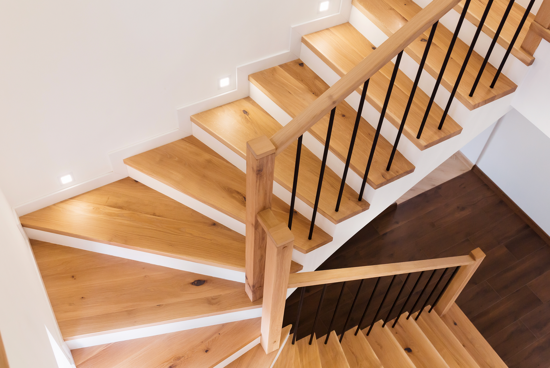 A wooden staircase with a black railing in a house