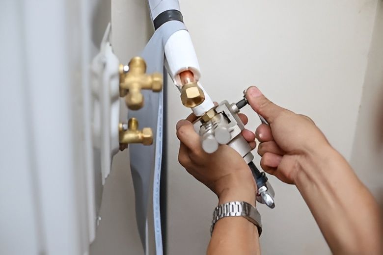 Person Adjusting a Valve on an Air Conditioning Unit — David Lewis Solahart in Bangalow, NSW