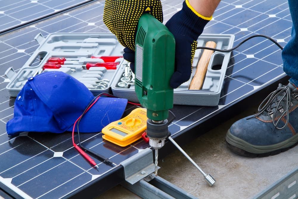 A Person Is Using A Drill To Fix A Solar Panel — David Lewis Solahart in Kingscliff, NSW