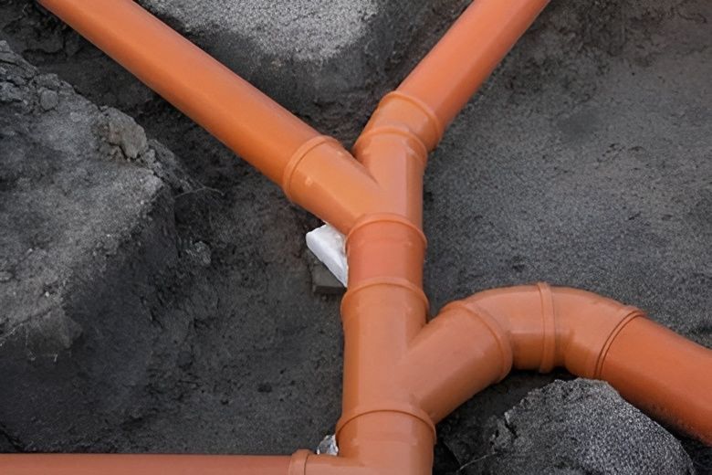 Orange Pvc Pipes Forming a Drainage System, Connected With Elbow — David Lewis Solahart in Mullumbimby, NSW